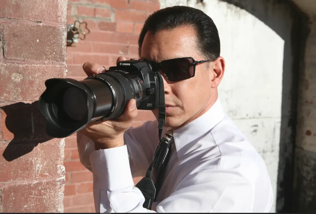 image of an infidelity investigator holding a camera wearing glasses